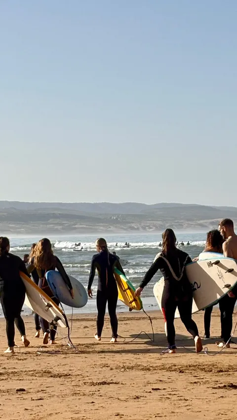 The first Lalla Surf retreat group walking the beach with boards